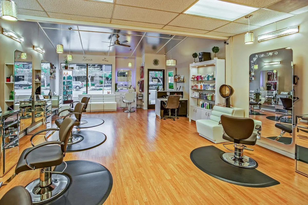 Empty hair salon interior with styling chairs, mirrors, and product shelves