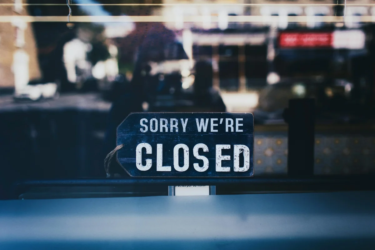 Sorry we’re closed sign hanging in a shop window